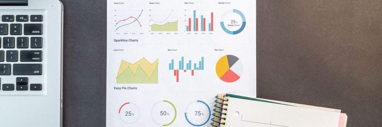 Desk with business charts, laptop and notebooks Desk with business charts, laptop and notebooks